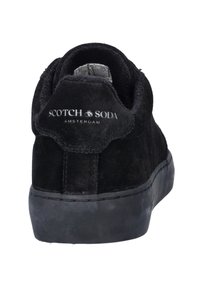 Black suede sneaker with thick black sole, branded "Scotch & Soda Amsterdam" on the heel tab, shown from the back.