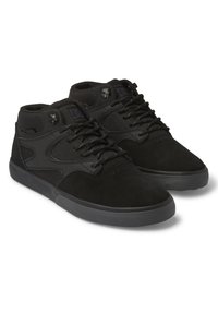 Black high-top sneakers made of a combination of mesh and suede, featuring a textured sole, padded collar, and metal eyelets for laces.