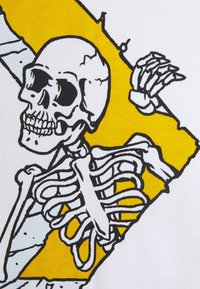 Esqueleto con cráneo y caja torácica detallados contorneados en negro, sosteniendo una tabla amarilla contra un fondo blanco.