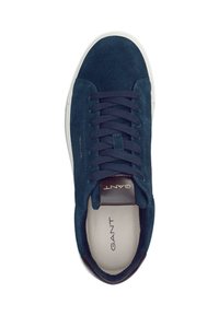 Zapatilla de gamuza azul marino con puntera redonda, diseño de cordones, suela de goma blanca, logotipo grabado en la lengüeta y acentos oscuros contrastantes.