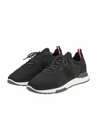Schwarze Sportschuhe aus Mesh- und Wildledermaterialien, mit einer weißen Sohle, strukturierten Details und roten sowie weißen Akzenten an der Kragen.