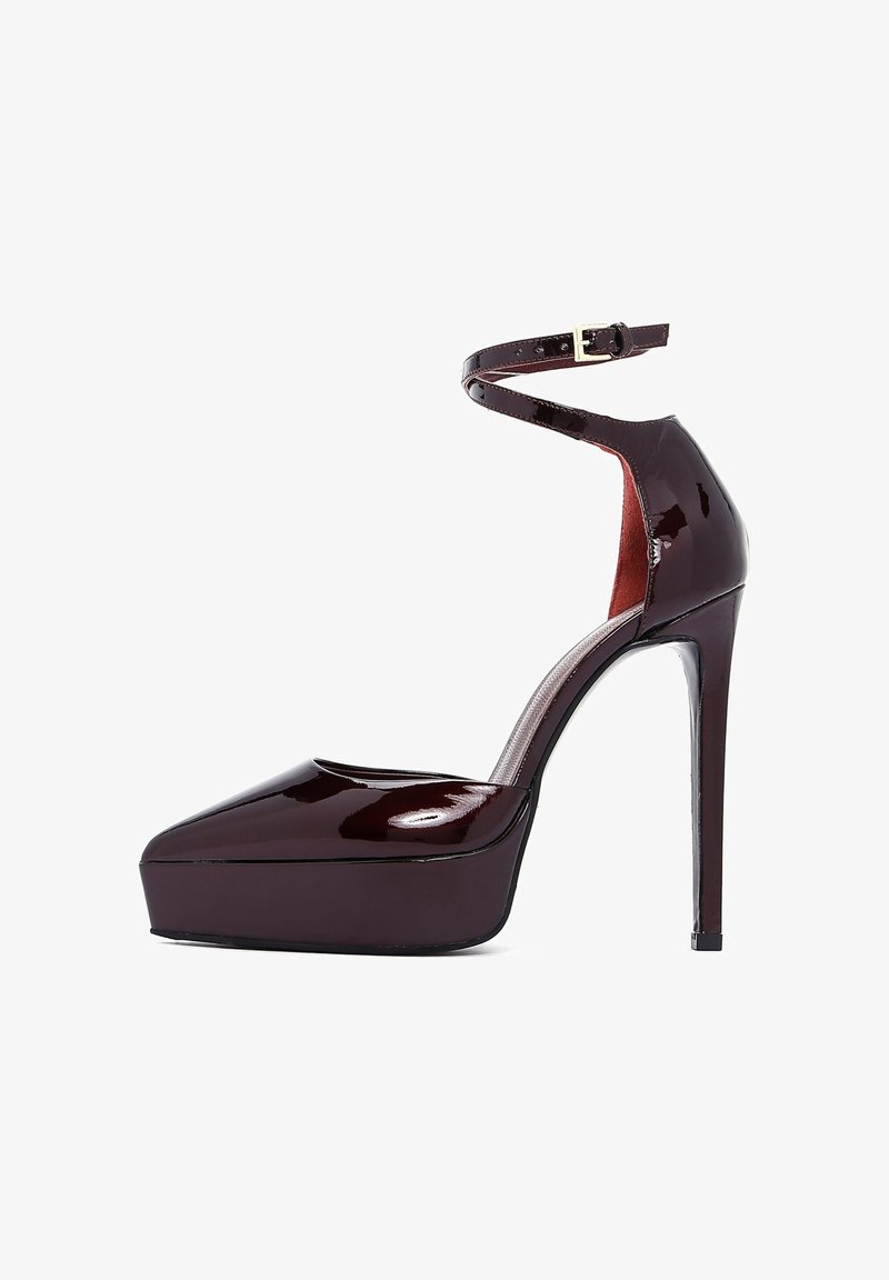 Glossy burgundy patent leather high-heeled shoe with a platform, pointed toe, ankle strap, and a stiletto heel.