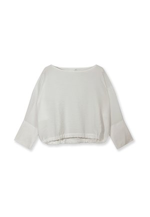 Blouse blanche à manches longues avec manches larges et ourlet élastique, présentée à plat sur un fond blanc.