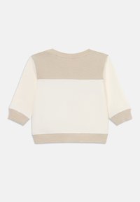 Krem- og beige genser med ribbestruktur på overdelen, kvartlengdes ermer og ensfarget nedre del.