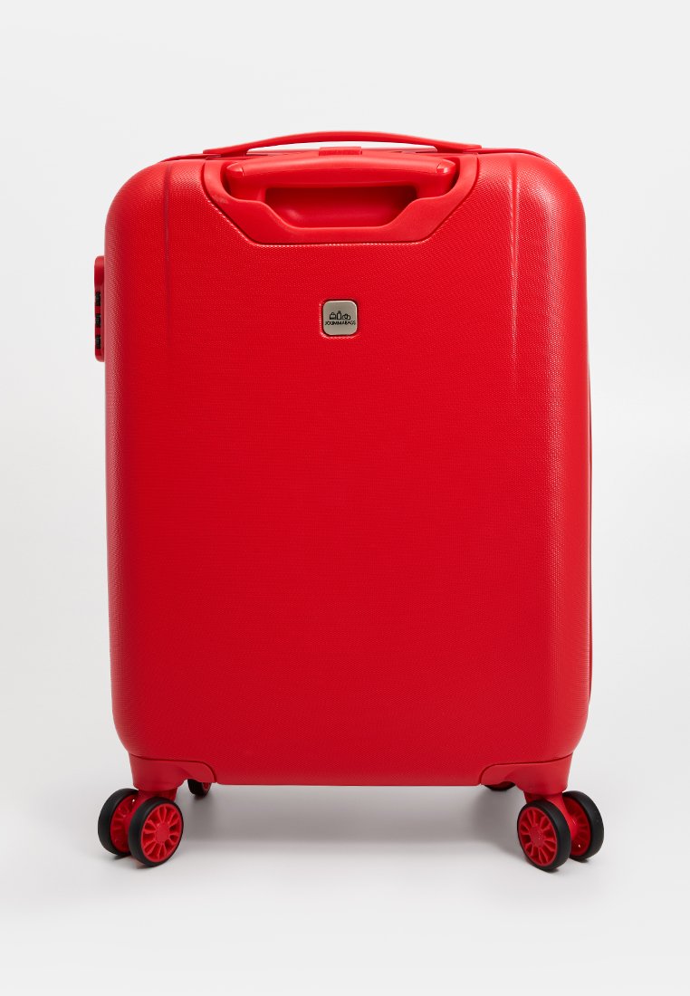 Roter Hartschalenkoffer mit strukturierter Oberfläche, zwei schwarzen Rollen und einem ergonomischen Traggriff. Verfügt über ein kleines, markiertes Logo auf der Vorderseite.