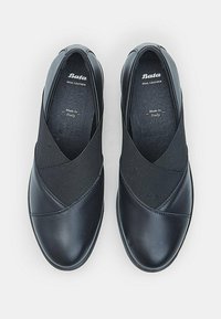 Fekete bőr cipők elasztikus betétekkel. Kerek orr, sima felület, minimalista dizájn. A belsejében található a "Bata" logó és a "Made in Italy" címke.