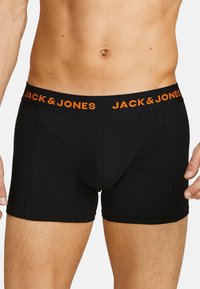 Schwarze Boxershorts aus einem glatten Stoff mit einem orangefarbenen "JACK & JONES" Logo am Bund. Eng anliegendes Design mit einer Länge bis zum Oberschenkel.