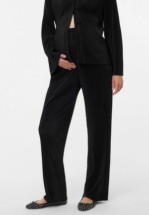 Schwarzes, gerippte Strick-Loungewear-Set mit einem durchgehenden Reißverschluss, weiten Ärmeln und passenden Hosen. Die Textur ist weich und glatt und zeichnet sich durch eine elegante Silhouette aus.
