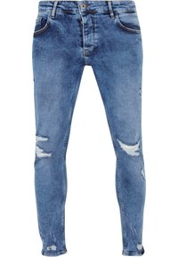 Jeans de mezclilla azul claro con un corte ajustado, que presentan desgarros en las rodillas, un desgaste sutil y el clásico estilo de cinco bolsillos.