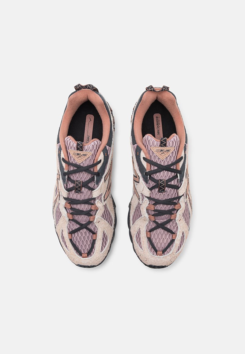Baskets de sport en mesh avec un schéma de couleurs rose clair et gris, dotées de lacets flexibles, d'un intérieur rembourré et de semelles texturées pour une bonne adhérence.
