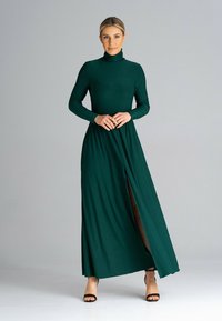 Zielona, długa sukienka maxi z długim rękawem, stojącym kołnierzem i rozcięciem z przodu, wykonana z gładkiego materiału. Zaprojektowana dla dopasowanego kroju.