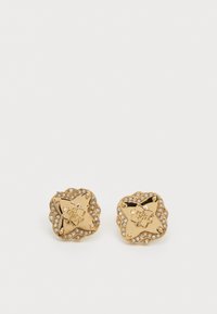 Boucles d'oreilles en forme d'étoile dorée avec gravure florale et entourées de petits strass transparents ; surface lisse avec une finition polie.