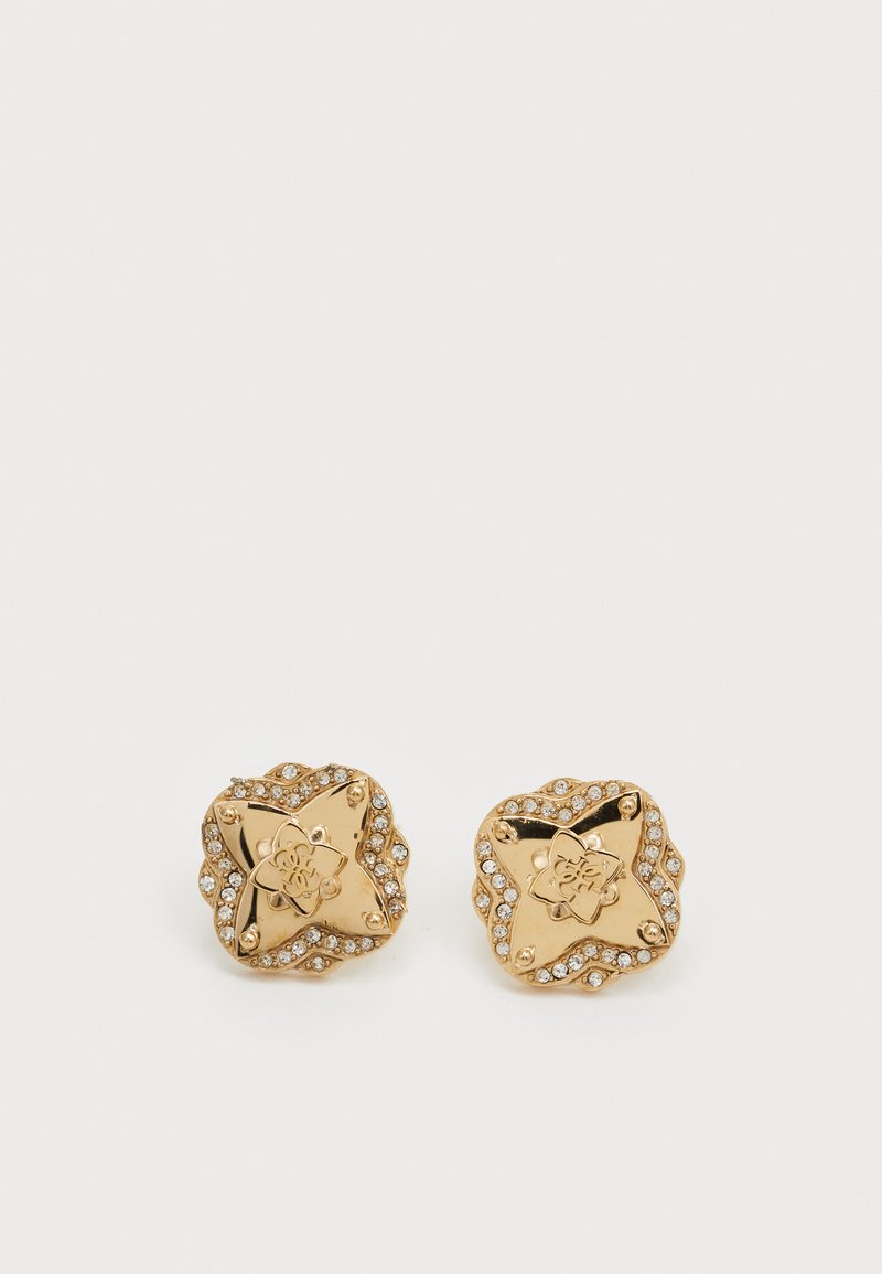 Boucles d'oreilles en forme d'étoile dorée avec gravure florale et entourées de petits strass transparents ; surface lisse avec une finition polie.