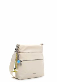 Beżowa torba na ramię z gładkiego syntetycznego materiału, z dwoma zamykanymi na zamek komorami, regulowanym paskiem oraz kolorowymi ozdobami w formie zawieszek.