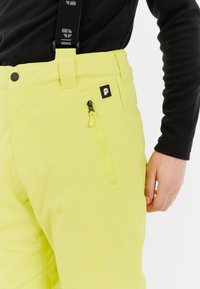 Felgeel waterdichte broek met verstelbare bretels, een voorzak met rits en een klein logo-opdruk nabij de taille. Glad textuur.