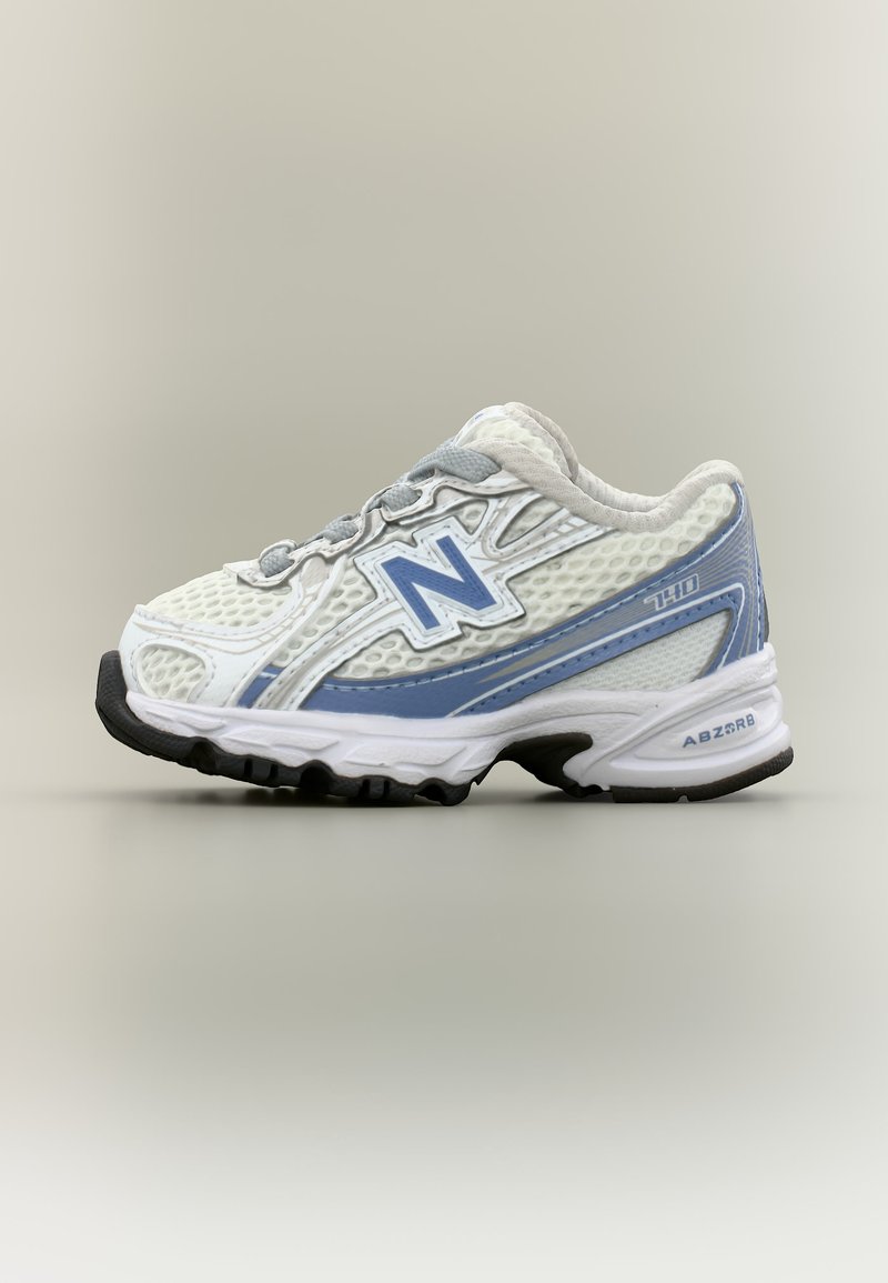 Άσπρο και ανοικτό μπλε παπούτσι για τρέξιμο New Balance με επάνω μέρος από διχτυωτό υλικό, μαλακή σόλα και μαύρη πέλμα, εμφανιζόμενο από την εξωτερική πλευρά.