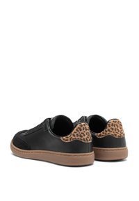 Scarpe da ginnastica nere con una parte anteriore in suede, dettagli a stampa leopardata sul tallone e suole in gomma marrone. Fianchi in pelle liscia, design con lacci.