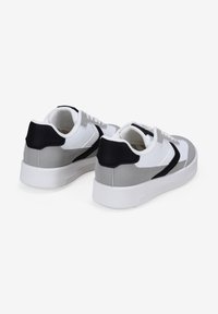 Sneaker bianchi e grigi con dettagli neri. Parte superiore in pelle liscia, punta arrotondata e colletto imbottito. Suola in gomma con battistrada testurizzato.