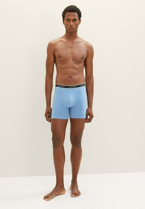 Lichtblauwe boxershort gemaakt van zachte, rekbare stof, met een zwarte tailleband met witte letters. Glad textuur, aansluitend ontwerp.