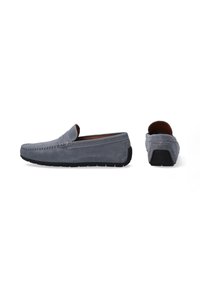 Graue Wildleder-Loafers mit einer flachen schwarzen Gummisohle, ausgestattet mit einer gesteppten Naht und einem weichen Innenfutter. Seitliche und Rückansicht sind enthalten.