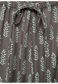Brown fabric shorts with a leaf pattern in light green. Features an elastic waistband with a drawstring for adjustable fit.
