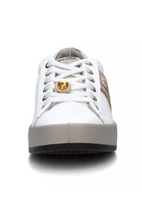 Sneaker bianco con lacci piatti, dettagli dorati e una striscia laterale beige. Presenta una texture lucida con un charm decorativo sui lacci.