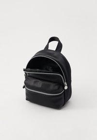 Svart syntetisk ryggsäck med rundad form, med silverfärgade dragkedjor och en framficka. Texturerat material med ett enda handtag upptill.