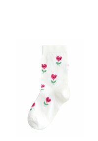 Hvid sok med lyserøde hjerteformede blomster med smilende ansigter og grønne stilke, mønster på stoffet.