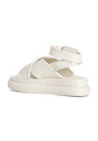 Bílé kožené sandály s křížovými popruhy a silnou platformou. Hladký povrch, minimální švy a žádné viditelné kování.