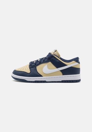 Sneakers Nike Dunk Low in pelle blu navy e beige, con logo bianco e suola in gomma testurizzata.