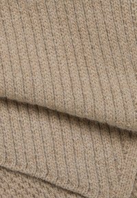 Tejido de punto acanalado beige con una textura suave, que presenta líneas verticales y una apariencia acogedora, ideal para aplicaciones textiles o prendas.