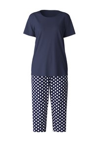 Donkerblauwe t-shirt met korte mouwen, gecombineerd met polka dot broek in navy en wit. De broek heeft een cropped lengte en een elastische tailleband.
