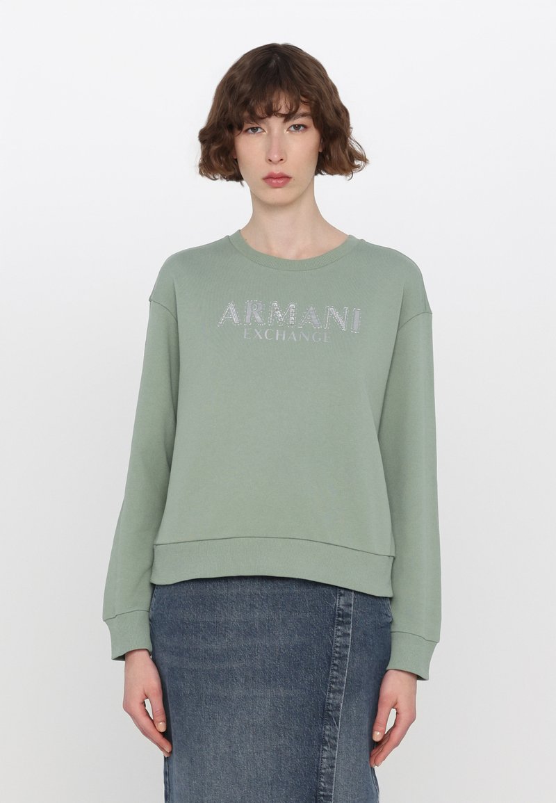 Světle zelená mikina vyrobená z měkké tkaniny, s kulatým výstřihem a žebrovanými manžetami. Na přední straně se nachází lesklé logo "ARMANI EXCHANGE".