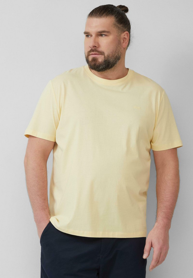 Korte mouwen gele T-shirt van zachte katoen, met een ronde hals en een klein logo op de borst. Geen opvallende patronen.