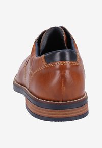 Scarpa di pelle marrone con finitura liscia, forma arrotondata e tacco nero a contrasto. Accenti cuciti e suola in gomma visibili.