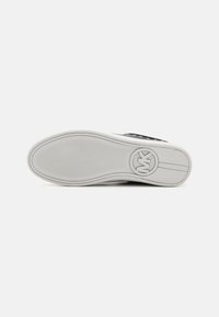 Semelle de sneaker noire avec une base en caoutchouc blanche, semelles texturées et accent logo circulaire. Présente des bords arrondis et une finition lisse.
