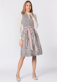 Graues traditionelles Kleid mit floralem Spitzenoverlay, rosa Satinband in der Taille und weißer strukturiertem Bluse mit langen Ärmeln und Knopfverschluss.