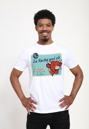 Bílý bavlněný tričko s grafikou "La Vache qui rit" z usmívající se krávy, vintage styl, modré pozadí a barevné textové akcenty.