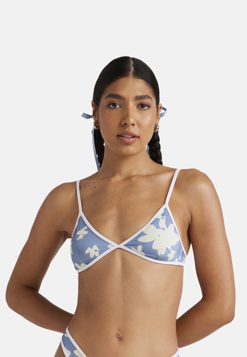 Kwiatowy stanik bikini w jasnoniebieskim kolorze z białymi wykończeniami; ma kształt trójkąta, cienkie ramiączka i miękką, gładką fakturę materiału.
