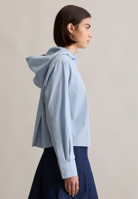 Lichtblauw, gestreept, cropped hoodie met lange mouwen en knoopmanchetten. Glad materiaal met een relaxte pasvorm.