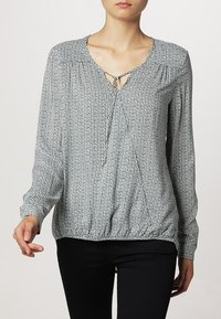 Bluzka z długim rękawem w kratę, z okrągłym dekoltem i wiązaniem, marszczonymi szwami na ramionach oraz ściąganym dołem. Wykonana z lekkiego materiału.