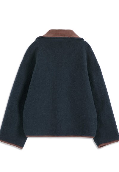 Veste polaire bleu marine foncé à manches longues avec bordure marron sur le col, les poignets des manches et l'ourlet, vue de dos sur fond blanc.