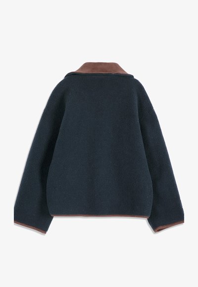 Veste polaire bleu marine foncé à manches longues avec bordure marron sur le col, les poignets des manches et l'ourlet, vue de dos sur fond blanc.