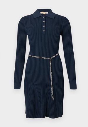 Robe bleu marine côtelée à manches longues avec col, boutonnée à l'avant, et ceinture en chaîne argentée pendante sur le côté.