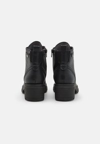 Stivaletti neri in pelle con una finitura liscia, cerniere laterali e tacco impilato. Anello di supporto sul retro per un facile indossamento.