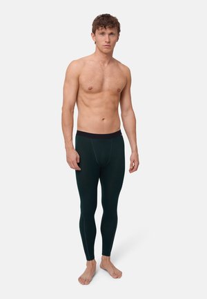 Dunkelgrüne Thermoleggings mit einem schwarzen elastischen Taillenbund, aus einem dehnbaren Stoff gefertigt. Die körpernahe Passform reicht bis zur Knöchellänge.