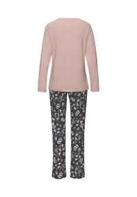 Rosa langärmliges Baumwolloberteil, kombiniert mit schwarzen, floral gemusterten Hosen. Das Oberteil hat einen runden Ausschnitt; die Hosen zeichnen sich durch einen figurbetonten Schnitt und helle Farben aus.