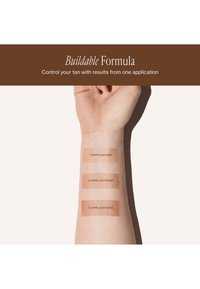 L'avant-bras présente trois nuances de bronzage numérotées 1, 2 et 3 applications, démontrant des teintes de formule modulables allant d'un bronzage clair à plus foncé.