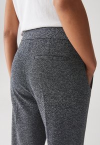 Pantaloni grigi strutturati con vita aderente, sottile motivo a macchia e tasche posteriori. Realizzati in un morbido tessuto elasticizzato.