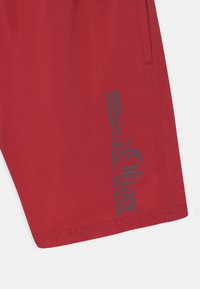 Røde shorts med en glatt tekstur, elastisk midjebånd, og et grafisk trykk i blått med teksten "s. Oliver" langs siden.